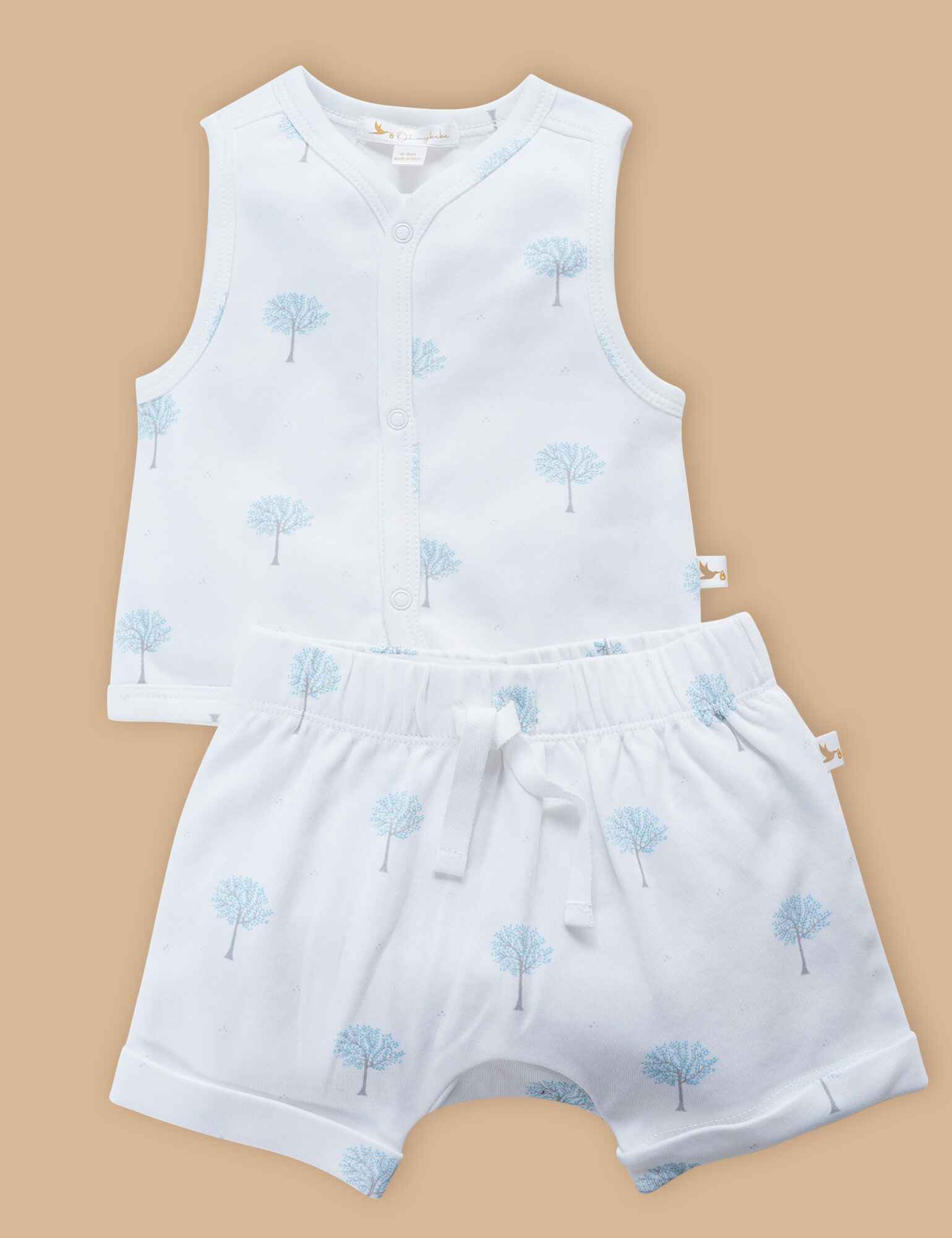 White baby sleeveless vest and shorts set with light blue tree pattern on beige background