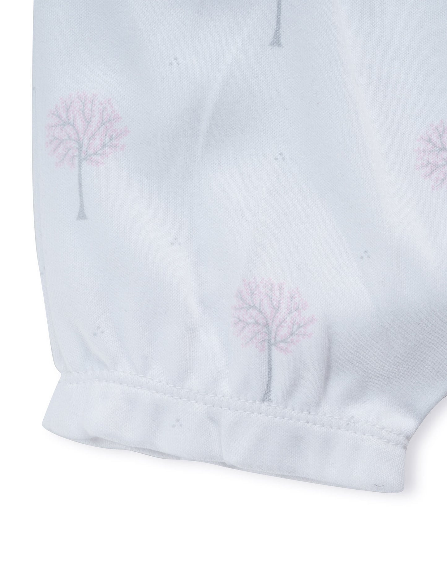 White fabric with pink blossom tree print and elastic cuff detail on sleeve