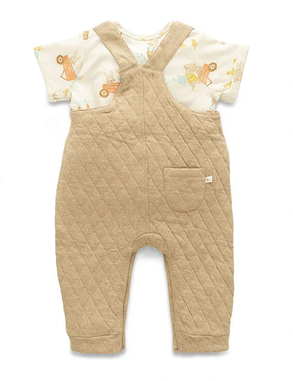 Baby outfit with beige quilted romper and patterned shirt on a white background