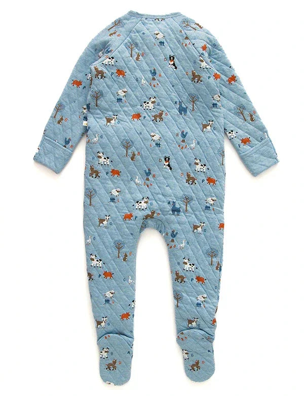 Back view of blue quilted baby romper with farm animal prints including cows, pigs, dogs, and trees