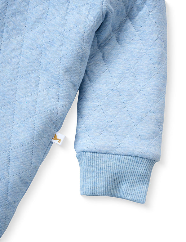 Blue quilted baby romper sleeve texture with soft ribbed cuffs – organic cotton.