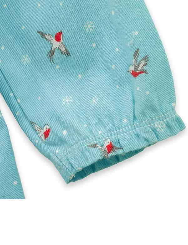 Close-up of blue fabric with bird print and elasticated sleeve cuff