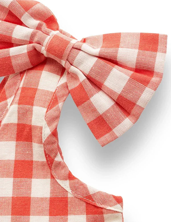 Close-up of coral gingham baby dress shoulder bow in soft cotton-linen fabric  