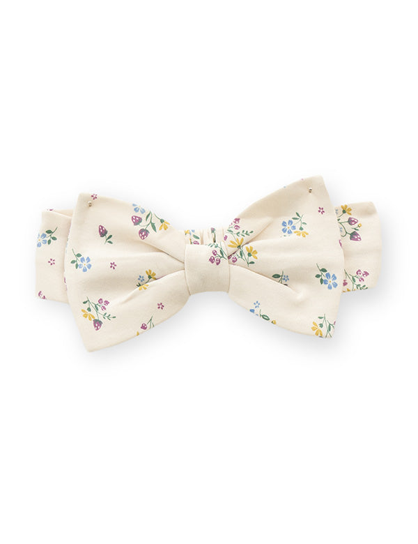 Close-up of floral bow headband matching the cream ruffle baby romper.   