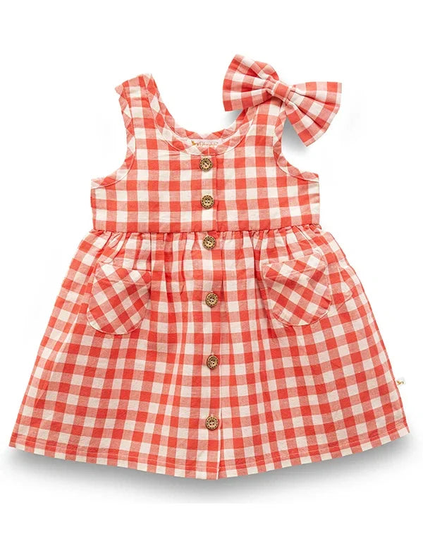 Coral gingham baby girl dress with wooden buttons and front pockets flatlay  