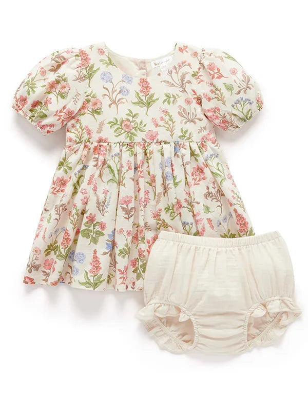 Organic cotton baby dress with puff sleeves and floral print, paired with beige bloomers