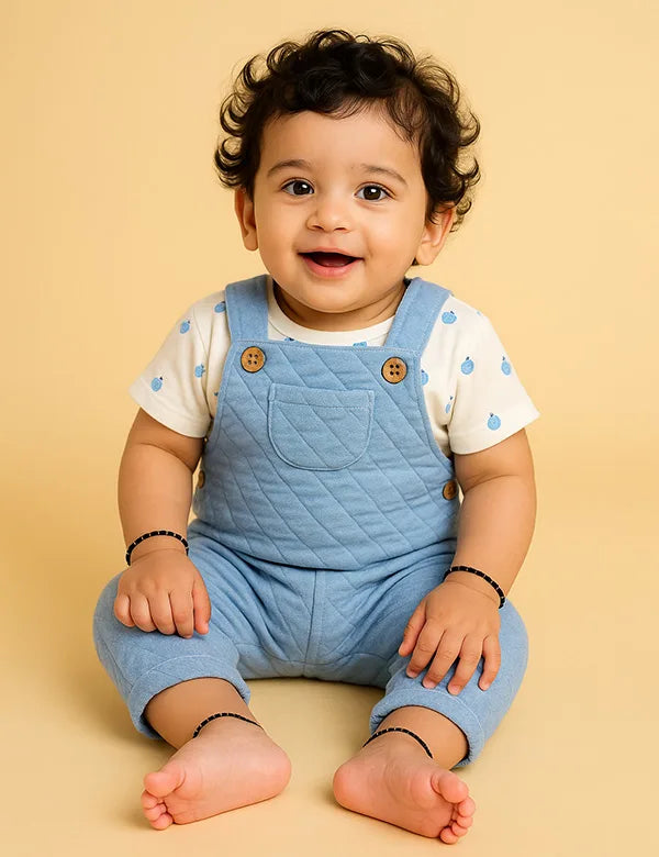 Light blue quilted baby dungarees paired with a white organic cotton tee featuring blue berry print