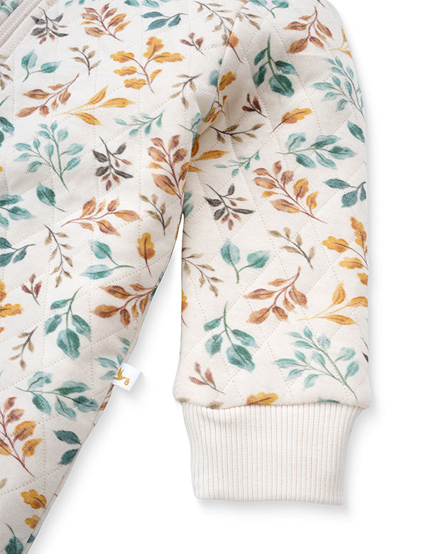 Close-up of floral quilted organic baby romper sleeve with ribbed cuff in soft cream fabric