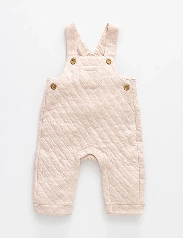 Soft pastel pink quilted baby dungaree with buttons and pocket on white background