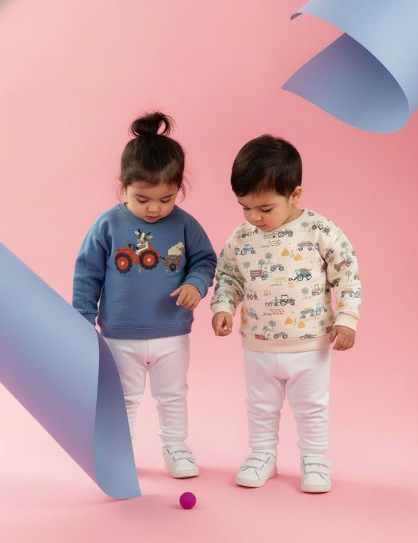Toddlers wearing organic cotton kids winter sweatshirts – blue tractor design and cream farm print