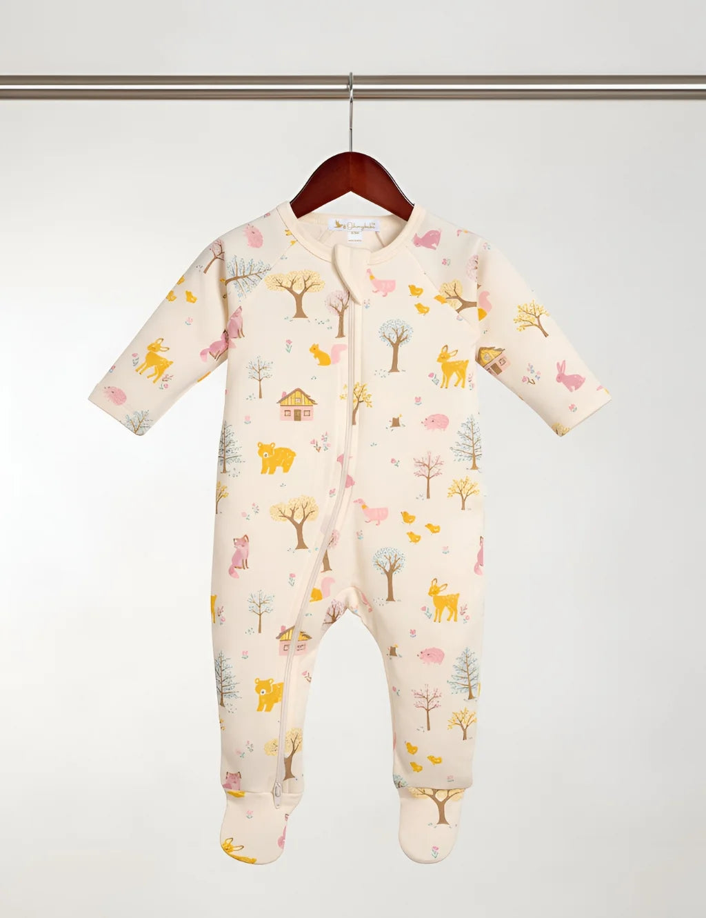 Baby onesie with animal print hanging on a rack against a white background