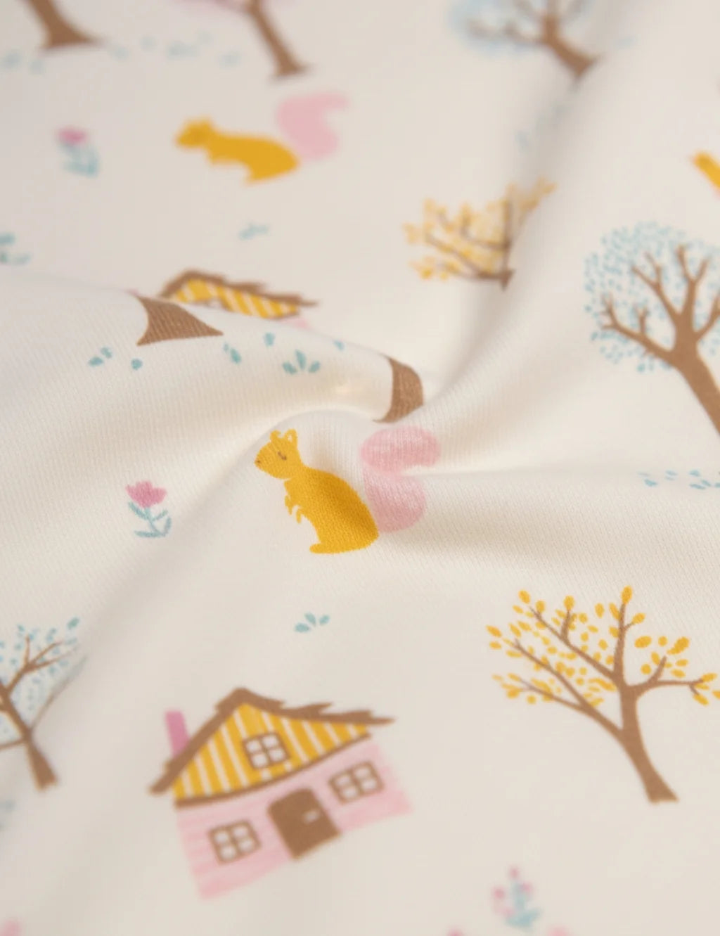 Fabric with autumn-themed pattern featuring houses, trees, and animals on a white background