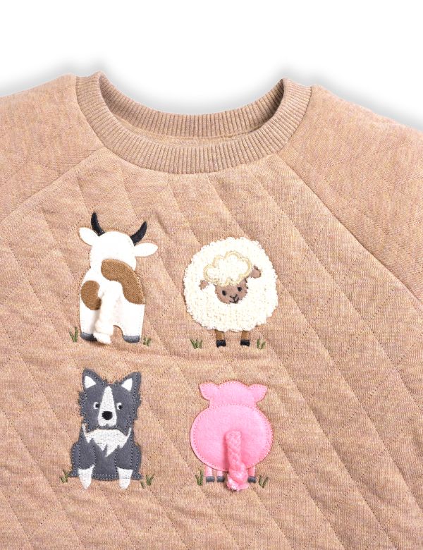 Beige sweater with appliqué of a cow, sheep, dog, and pig on a white background