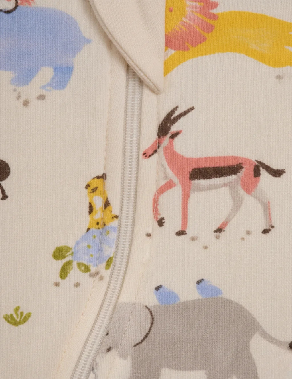 Close-up of a fabric with colorful animal pattern including deer, elephant, and giraffe.