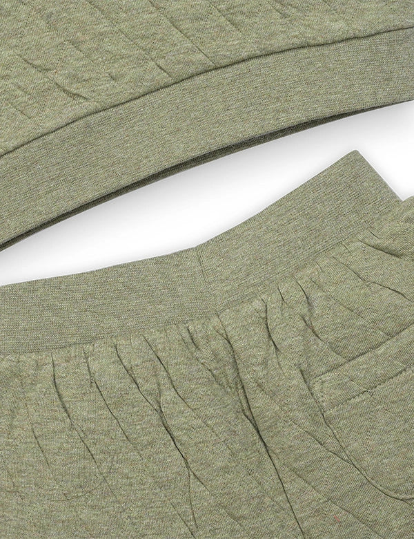 Close-up of green fabric with a textured pattern on a white background