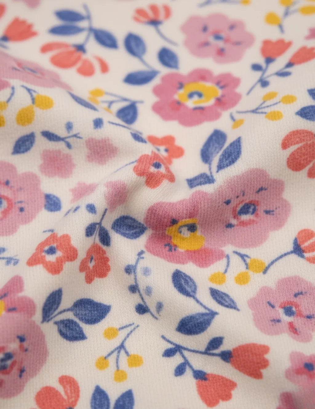 Floral patterned fabric with pink, blue, and red flowers on a white background
