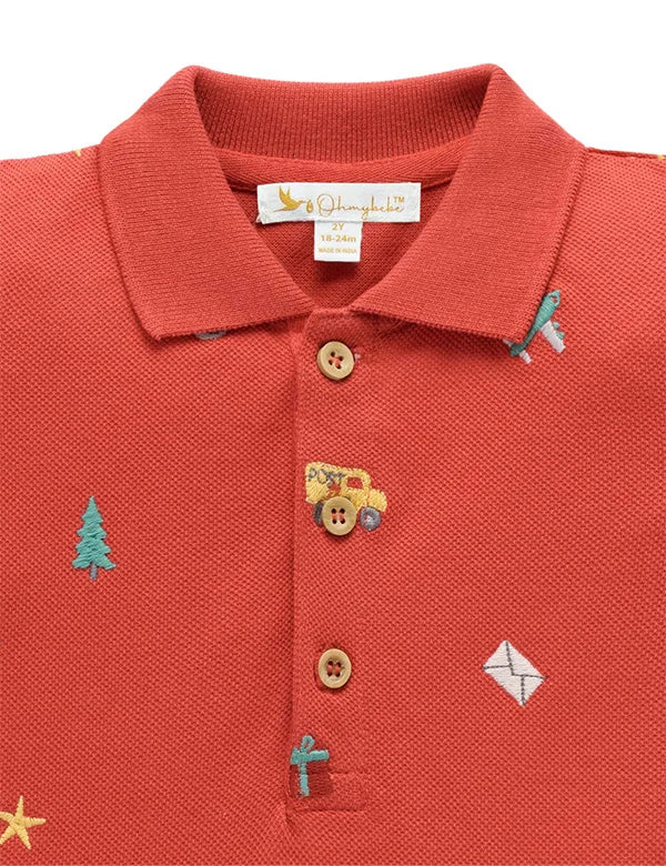 Red polo shirt with embroidered designs on a white background