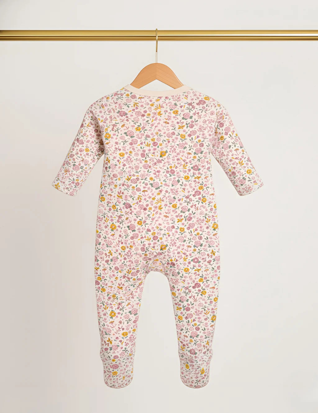 Floral-patterned baby onesie on a hanger against a white background