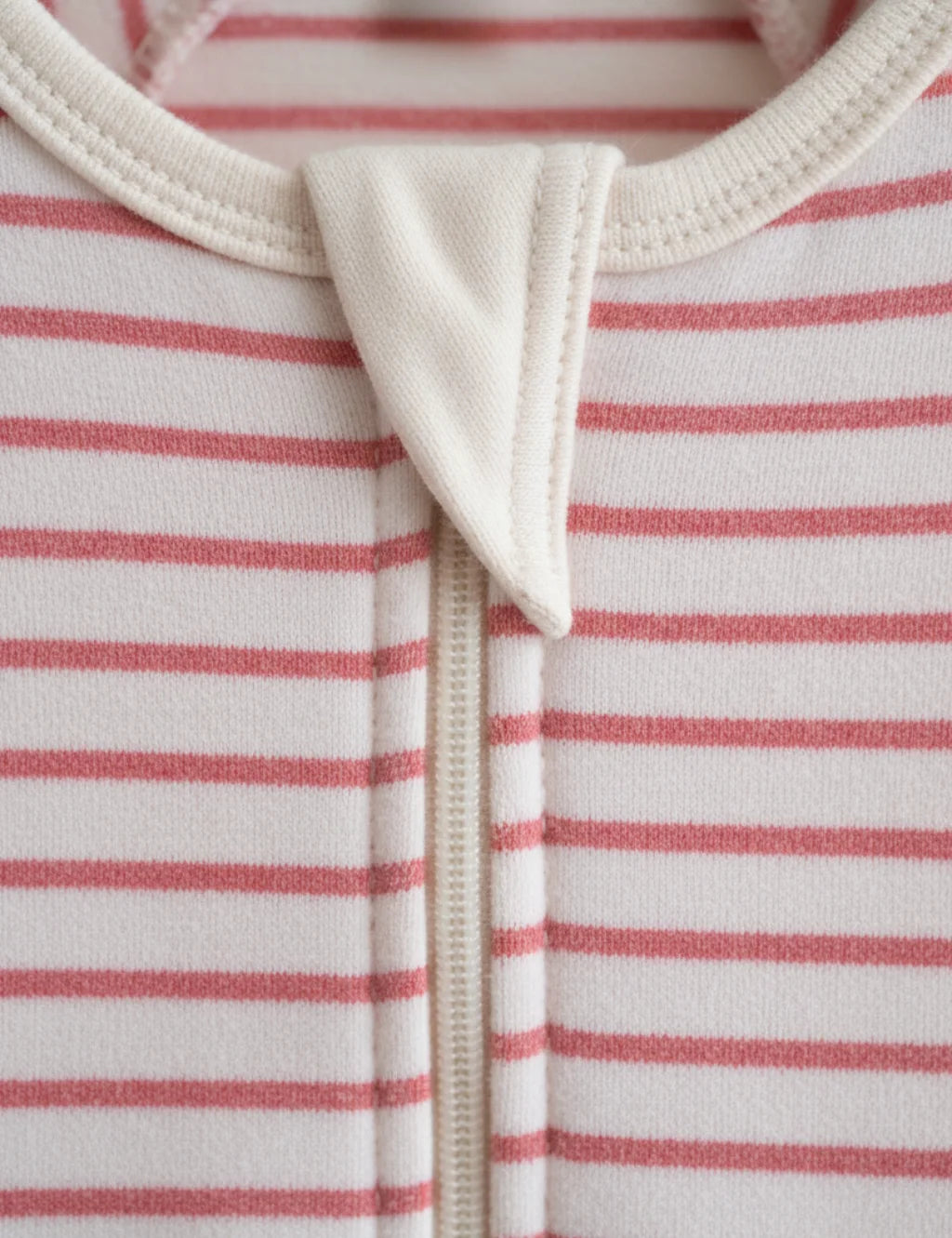 Close-up of a baby outfit with red and white horizontal stripes on a white background