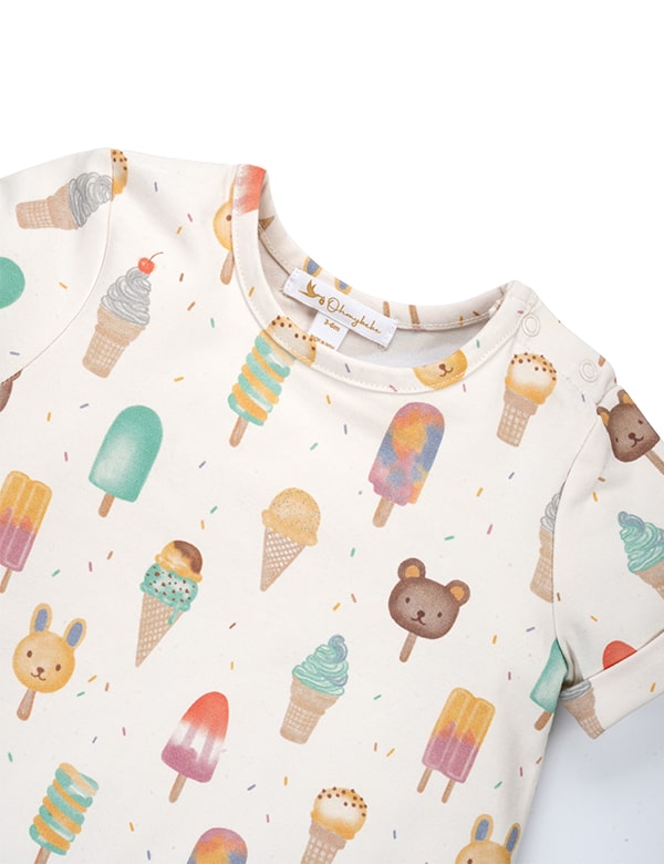 Close-up of baby onesie with colorful ice cream and animal popsicle prints on white fabric
