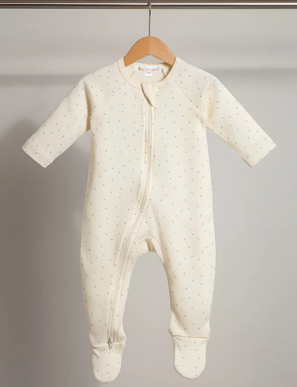 Baby onesie with a subtle pattern on a hanger against a plain background