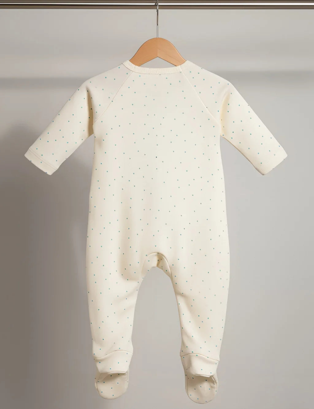 Baby onesie with a subtle pattern on a hanger against a plain background