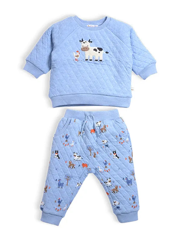  Organic quilted baby winter clothes set in blue with embroidered cow on sweatshirt and farm print joggers — front view.