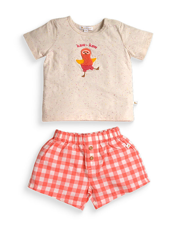 Baby outfit with speckled beige T-shirt featuring cartoon bird and text 'kaw-kaw', paired with red and white checkered shorts