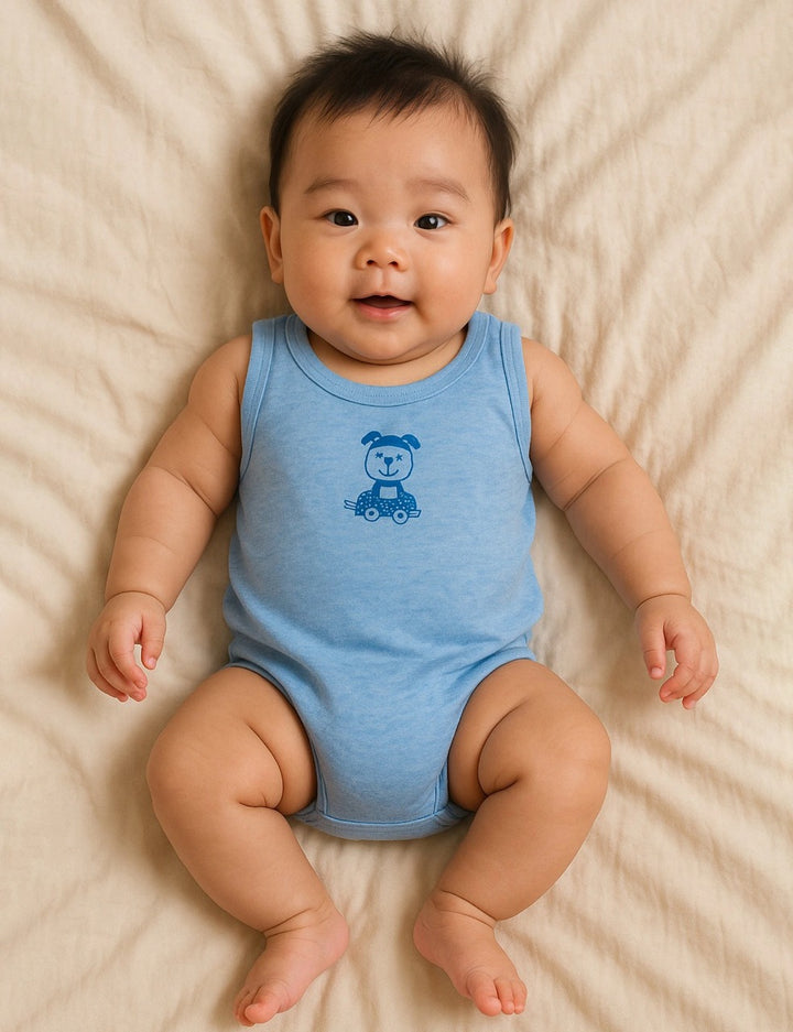 Smiling baby, who appears to be of East Asian descent, wearing a light blue ohmybebe organic cotton jabla with a dog print on a car. Buy comfortable baby vests online in India.