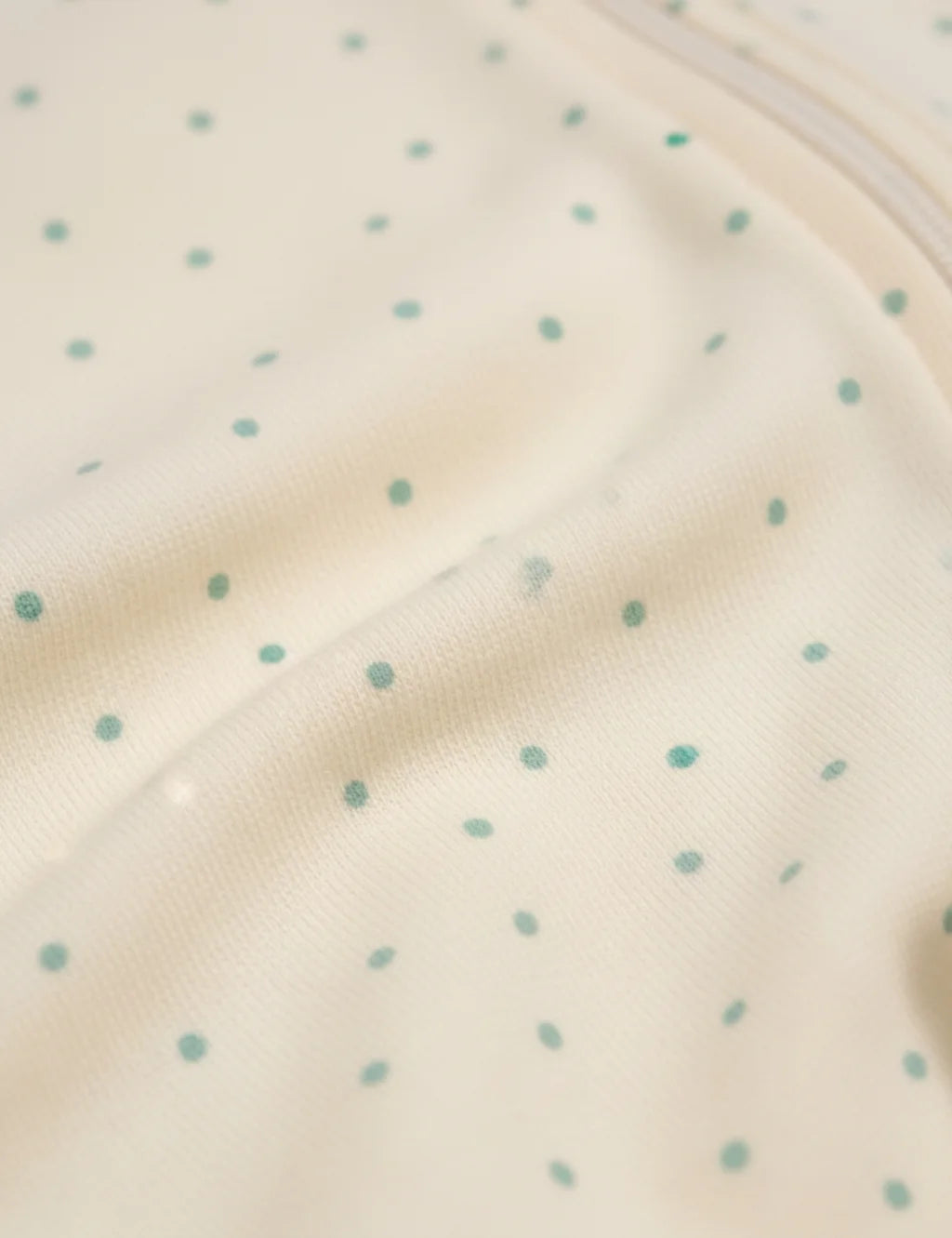 Close-up of a beige fabric with small blue polka dots