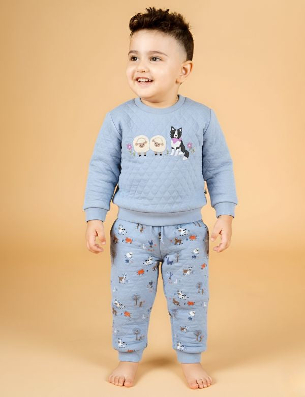 Child wearing a blue pajama set with animal designs on a beige background