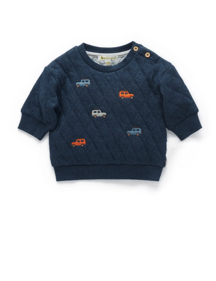Blue quilted sweatshirt featuring colorful small car designs and two buttons on the shoulder.