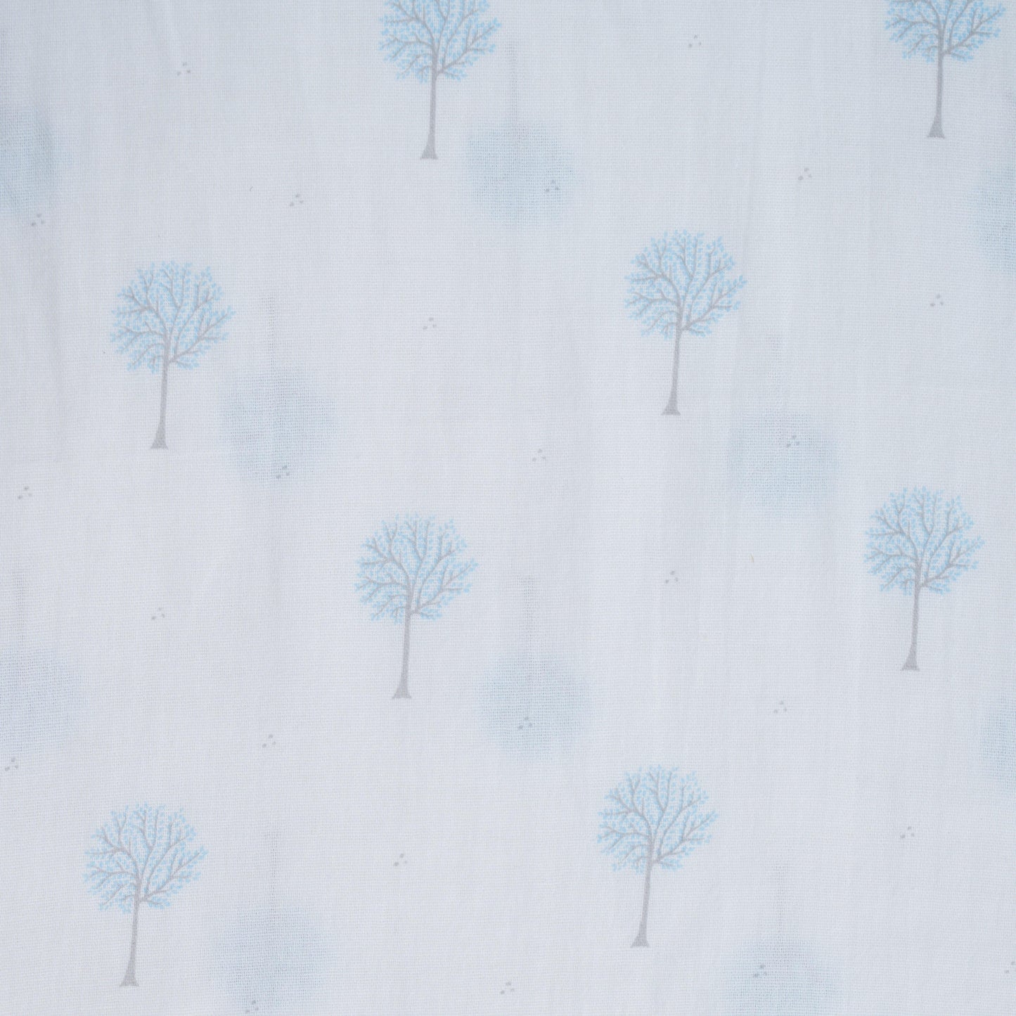 Close-up of white baby swaddle fabric with blue tree pattern and subtle gray dots