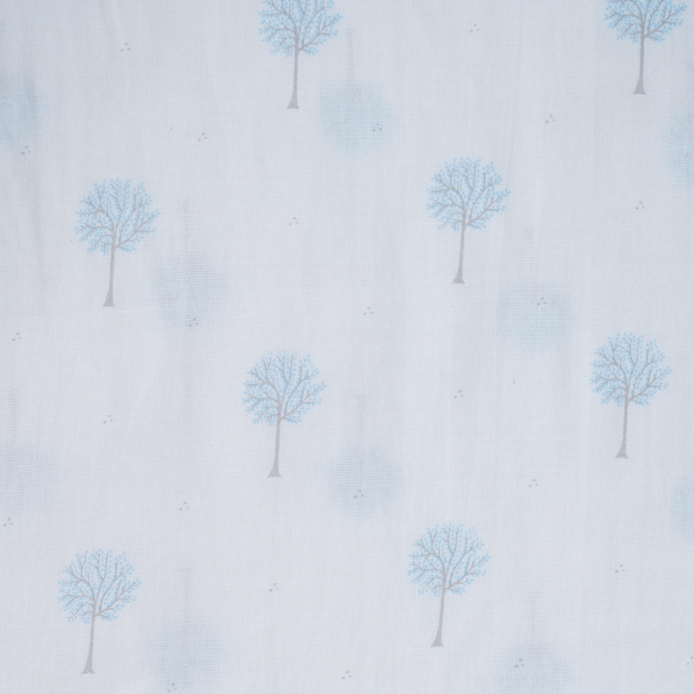 Close-up of white baby swaddle fabric with blue tree pattern and subtle gray dots