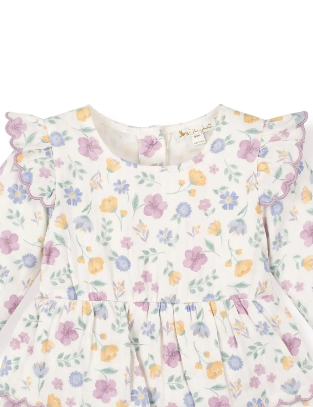 Close-up of a floral tiered dress romper showcasing the purple scalloped ruffle shoulder sleeves and neckline.