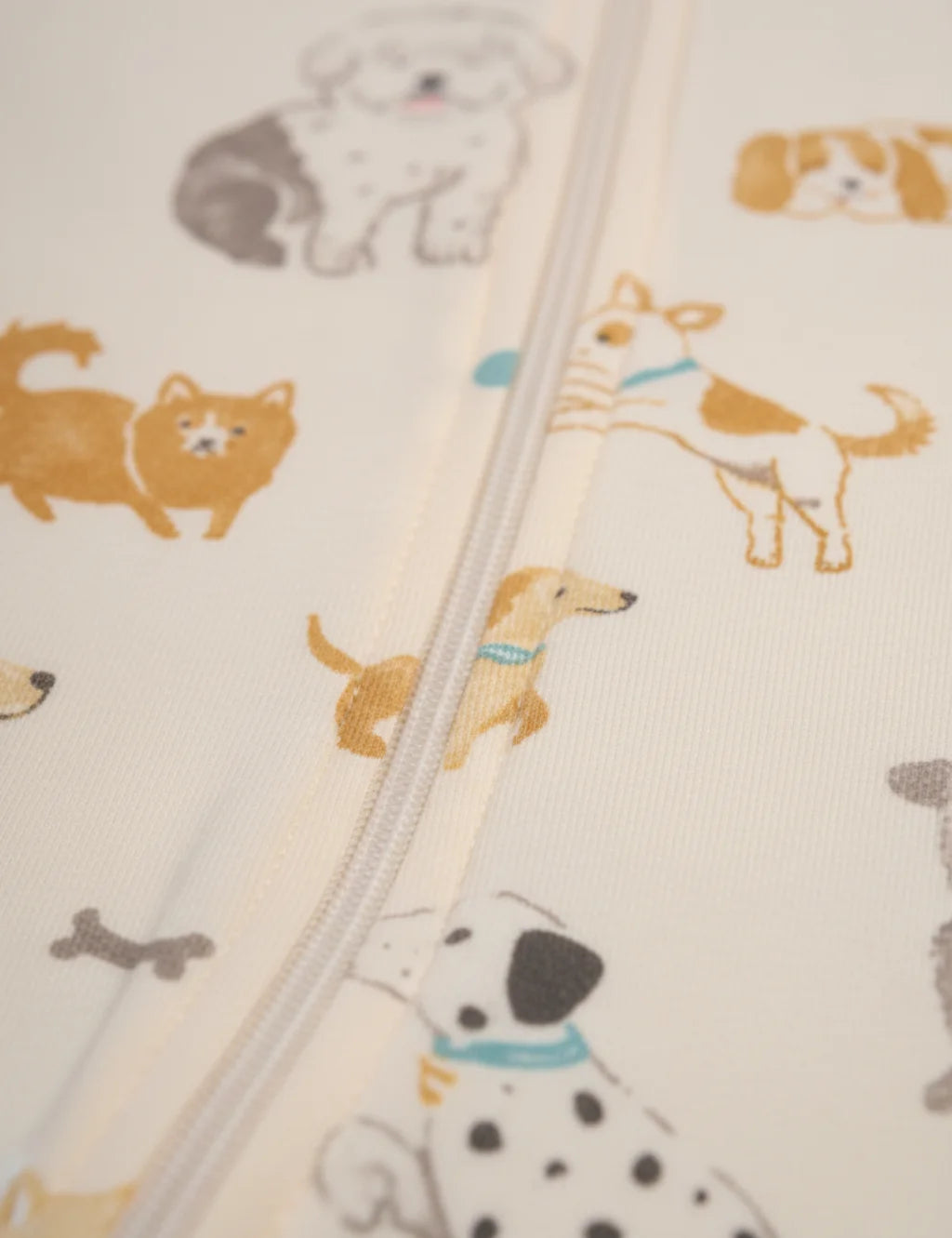Fabric with dog and cat patterns and a zipper running vertically.