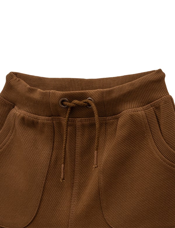 Close-up of brown sweatpants waistband with elastic band and drawstring detail