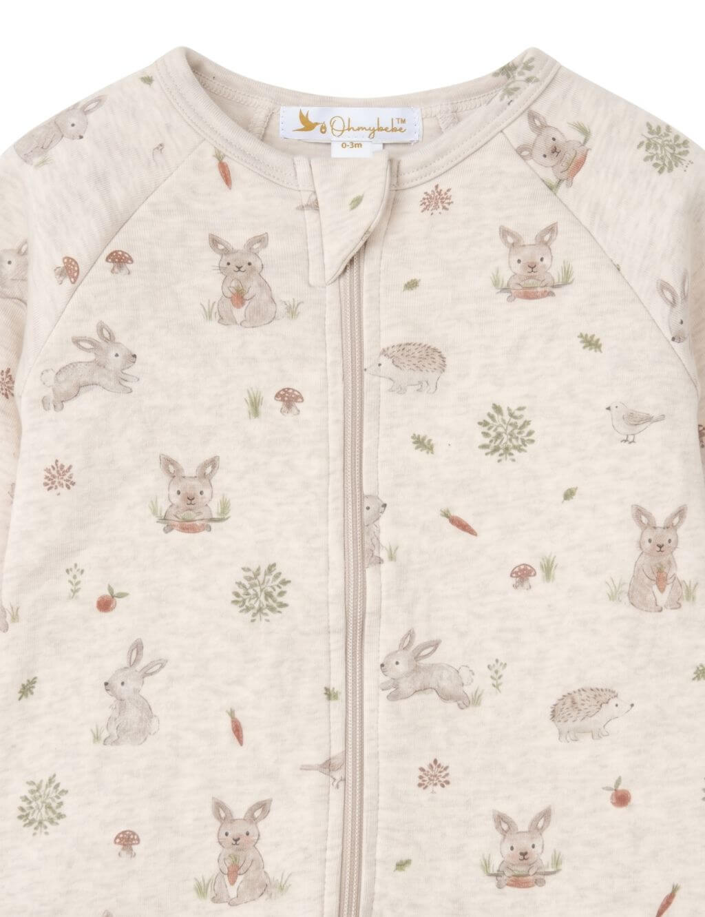 Close-up fabric detail of an organic cotton footie romper showing the neckline, zipper guard, and woodland bunny and hedgehog print