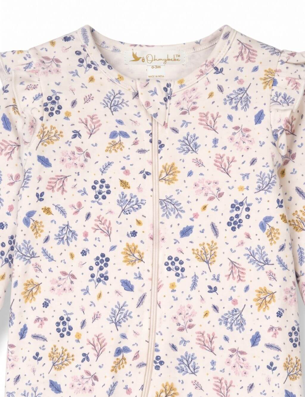 Close-up fabric detail of an organic cotton floral print romper showing the botanical pattern and shoulder ruffles