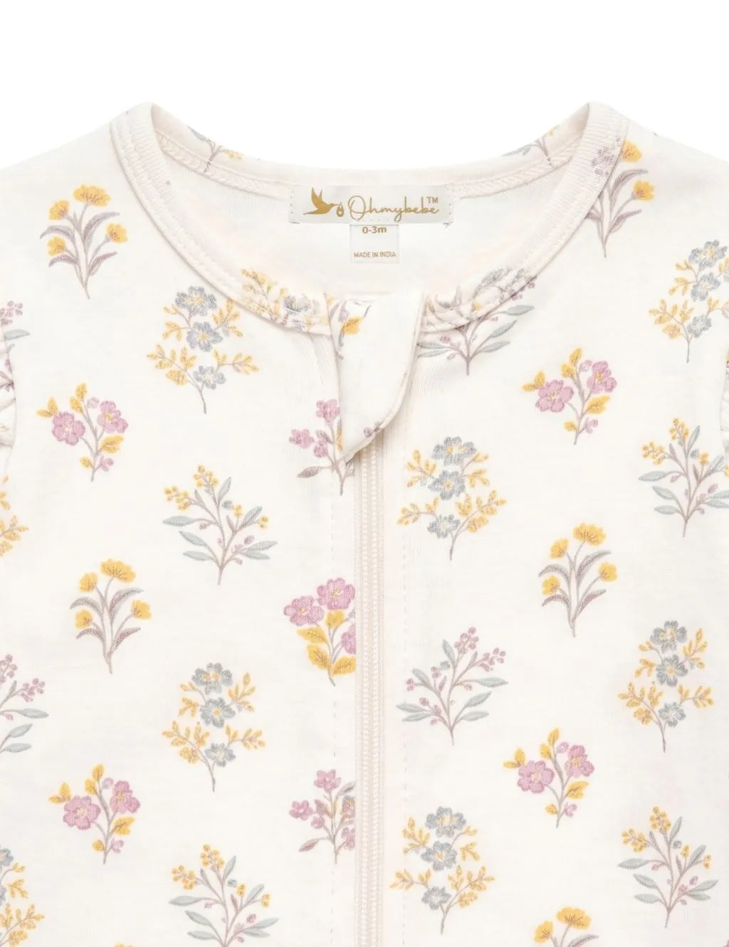 Close-up fabric detail of an organic cotton floral print romper showing the neckline, zipper guard, and botanical pattern.
