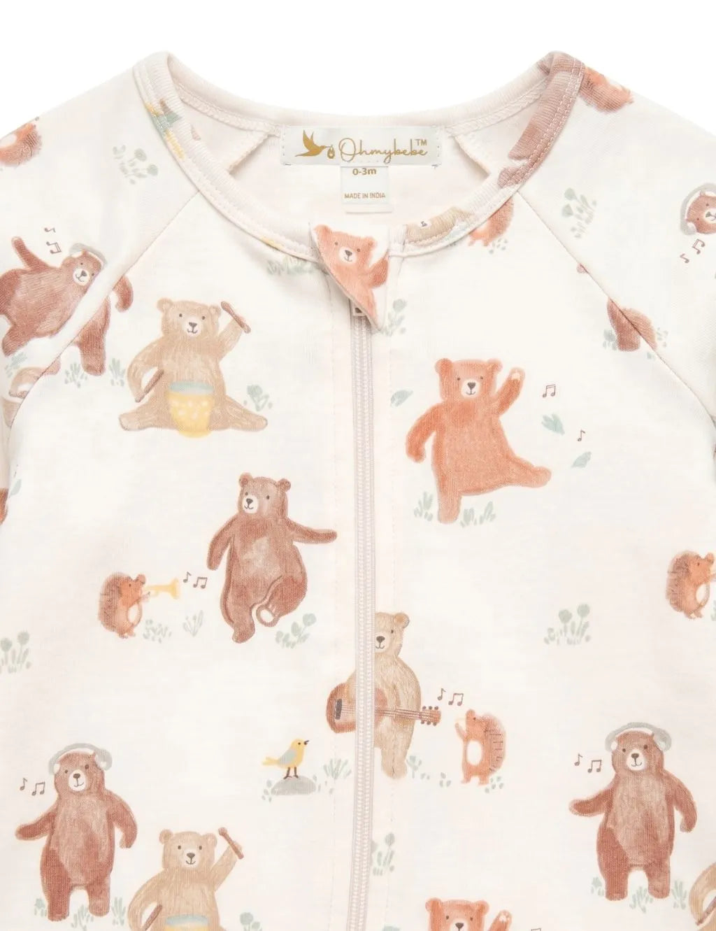 Close-up fabric detail of an organic cotton footie romper showing the neckline, zipper guard, and musical bear print.