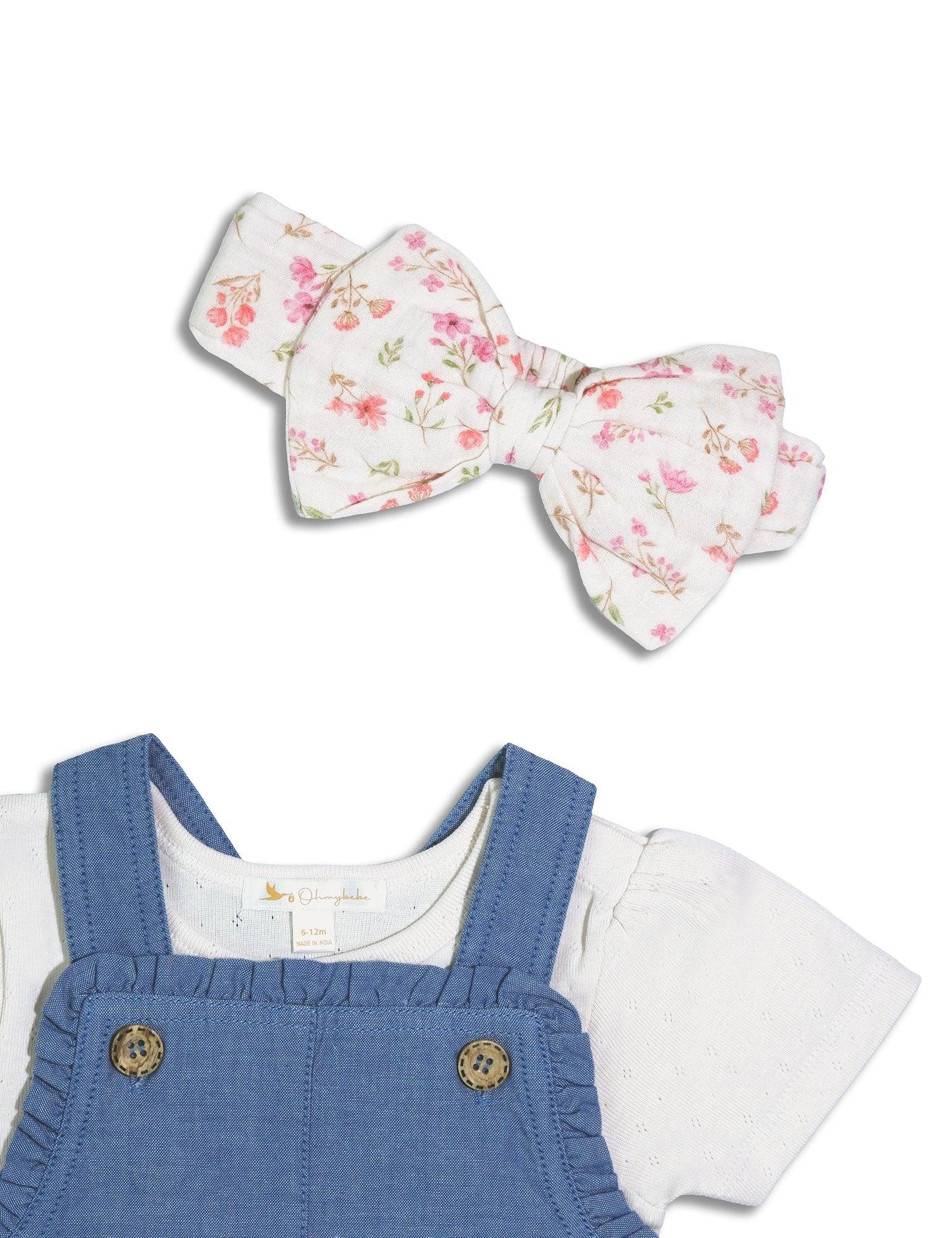 White floral bow headband with pink and green flower print paired with white top and blue denim dungaree