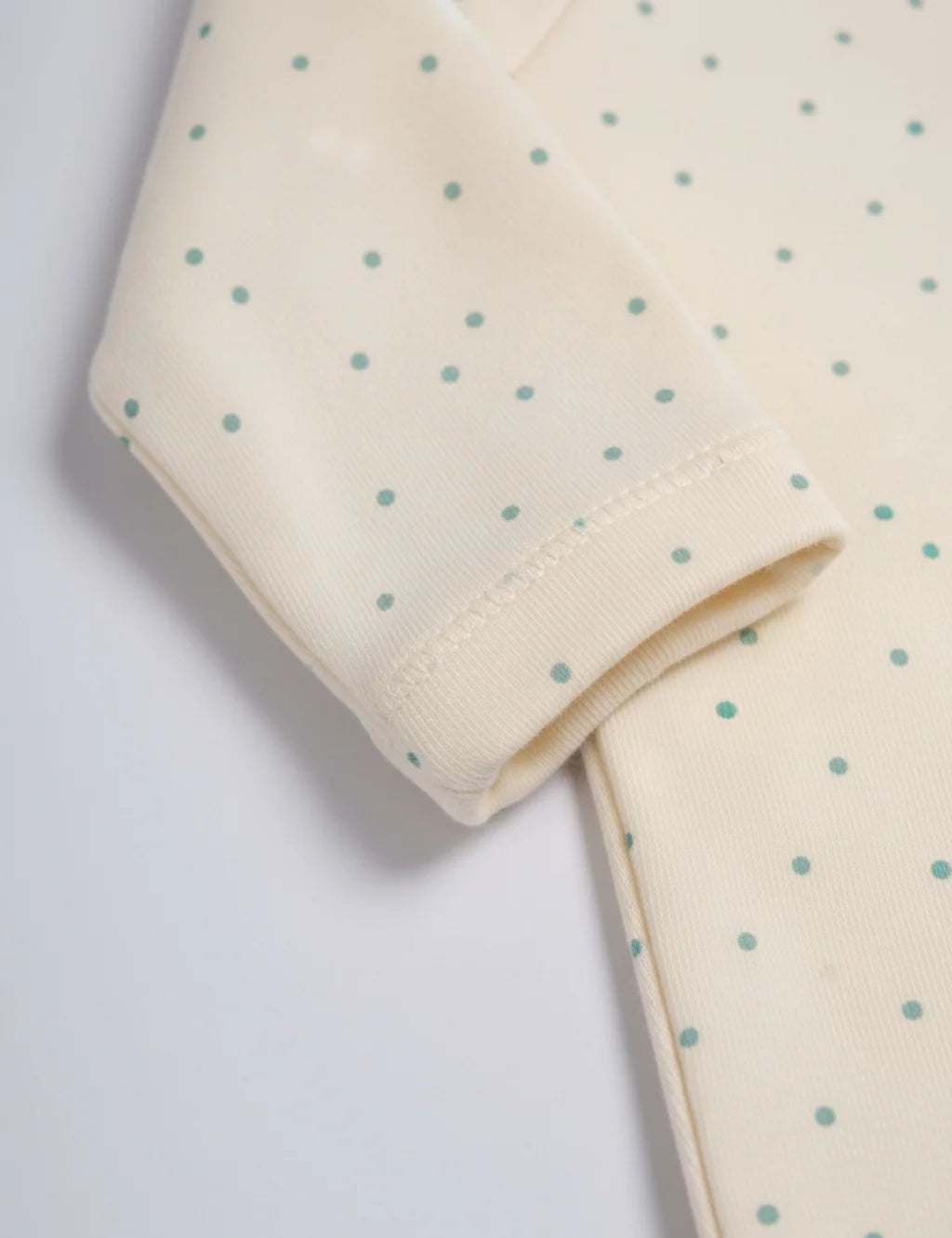 Folded fabric with small blue dots on a light background