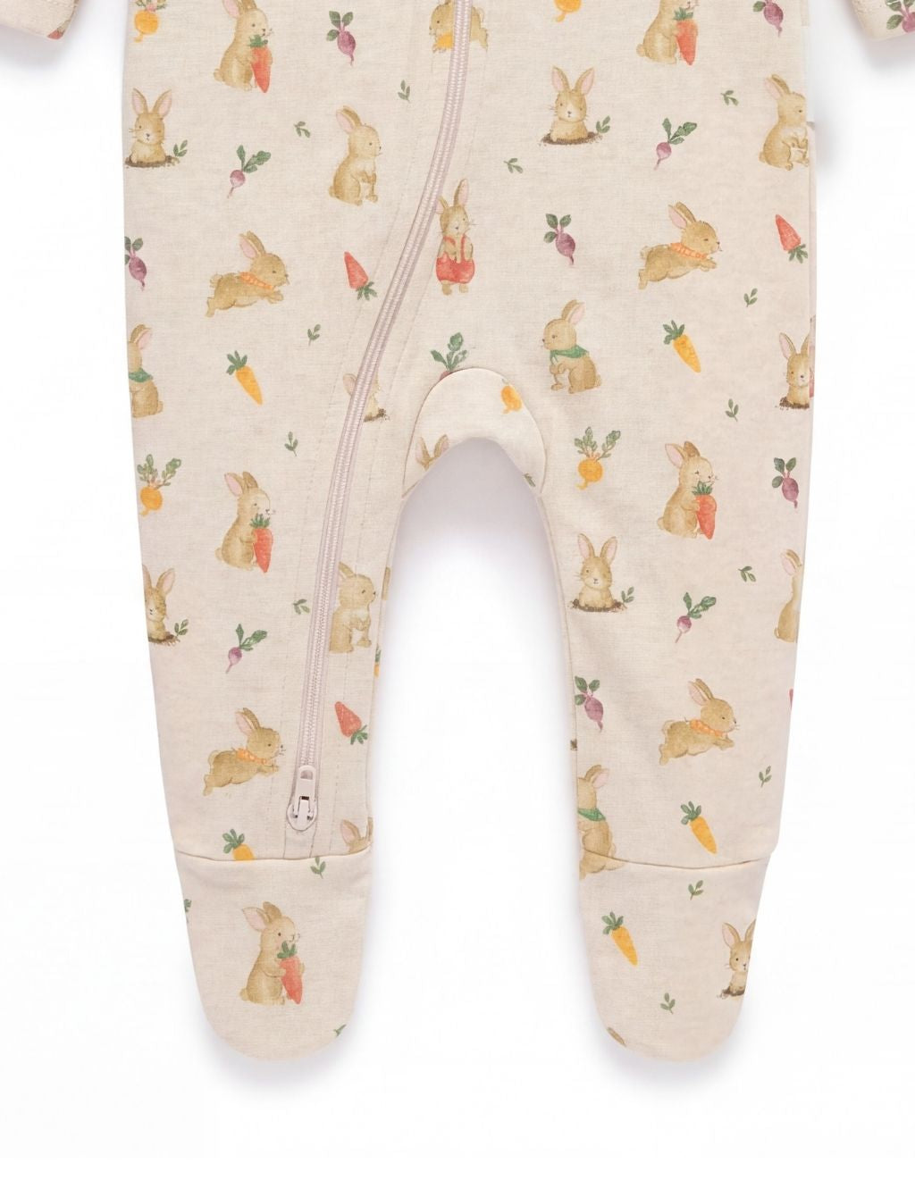 Close-up of the footed legs and diagonal zipper on a bunny print baby romper.