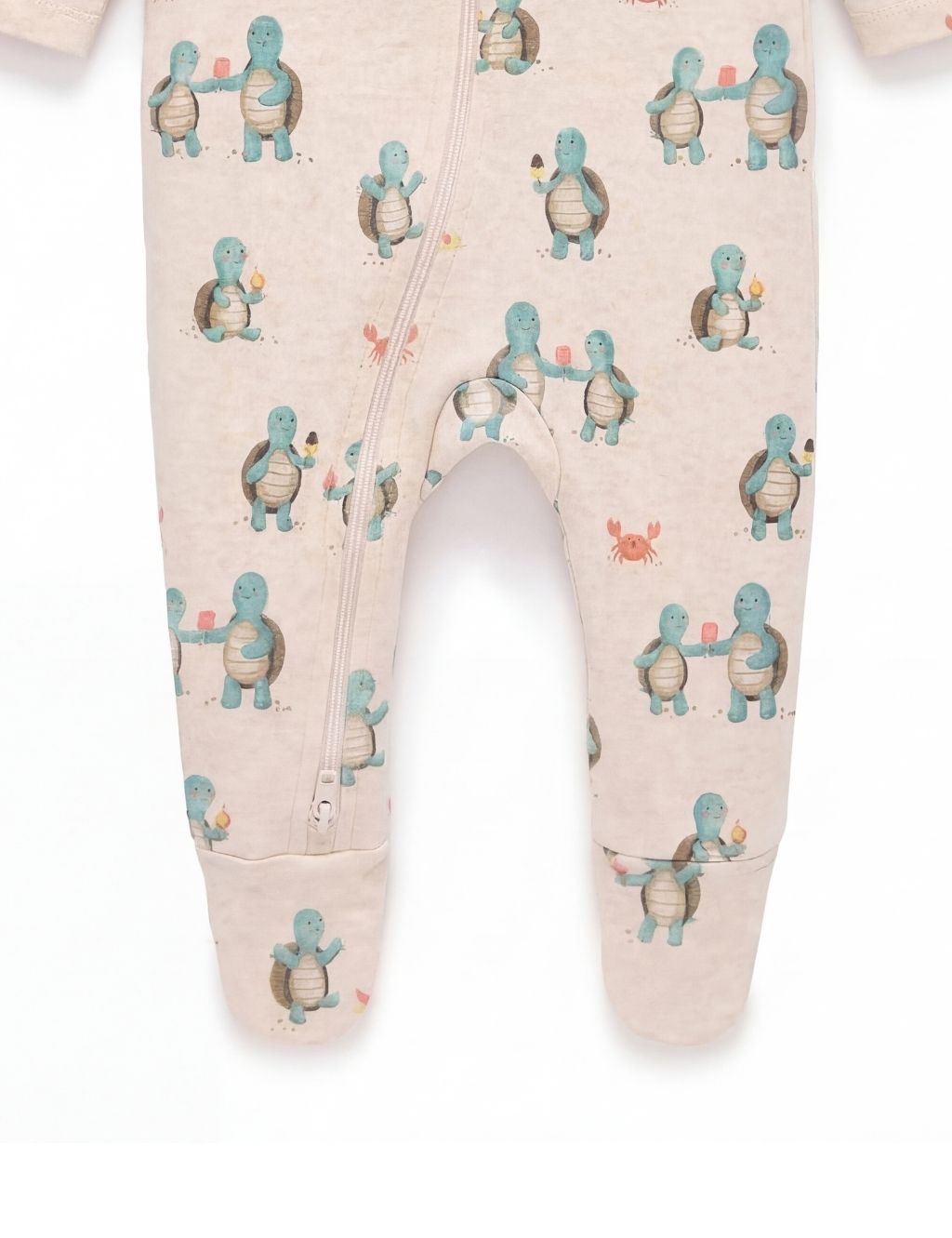 Close-up of the footed legs on an organic cotton baby zipper romper with turtle prints.