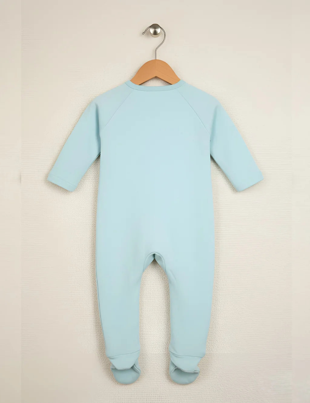 Light blue baby onesie on a hanger against a beige background