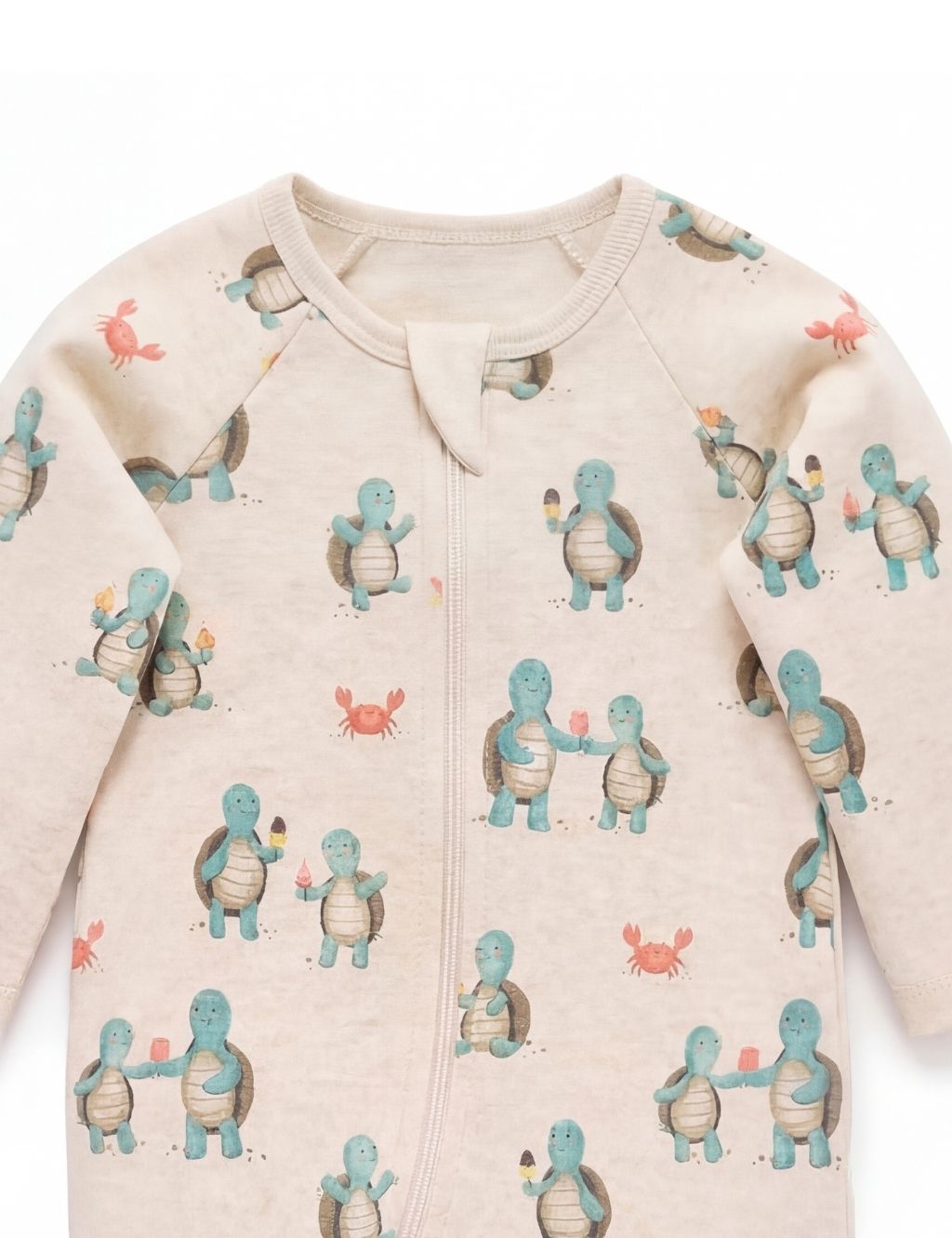 Close-up of the neckline and zipper on a beige organic cotton hungry turtle baby romper.