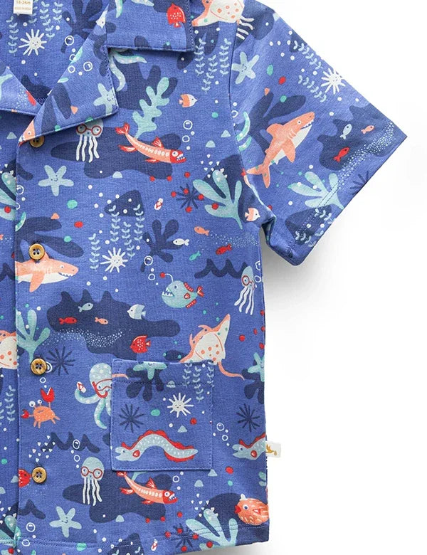 Blue short-sleeve shirt with marine life print including sharks, jellyfish, and coral details