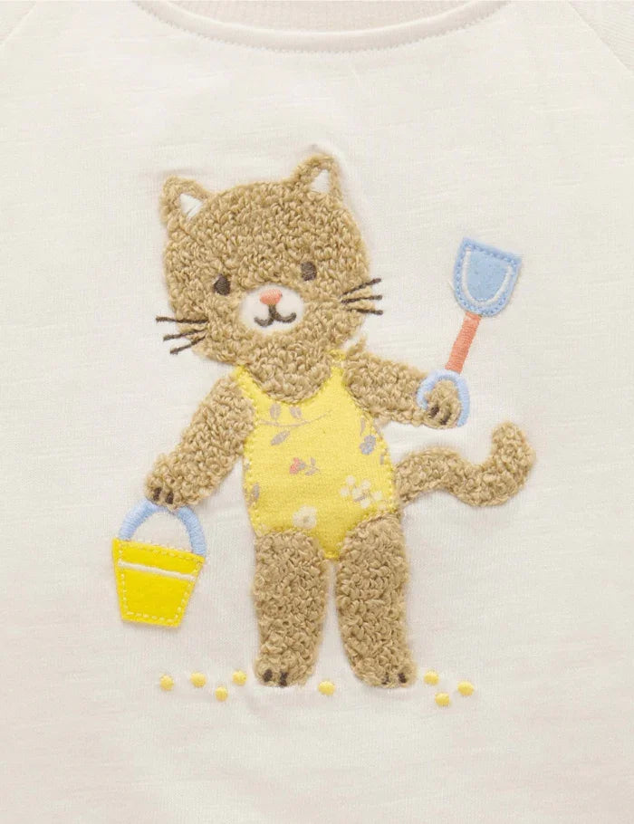 Embroidered cat in yellow swimsuit holding bucket and shovel on white fabric