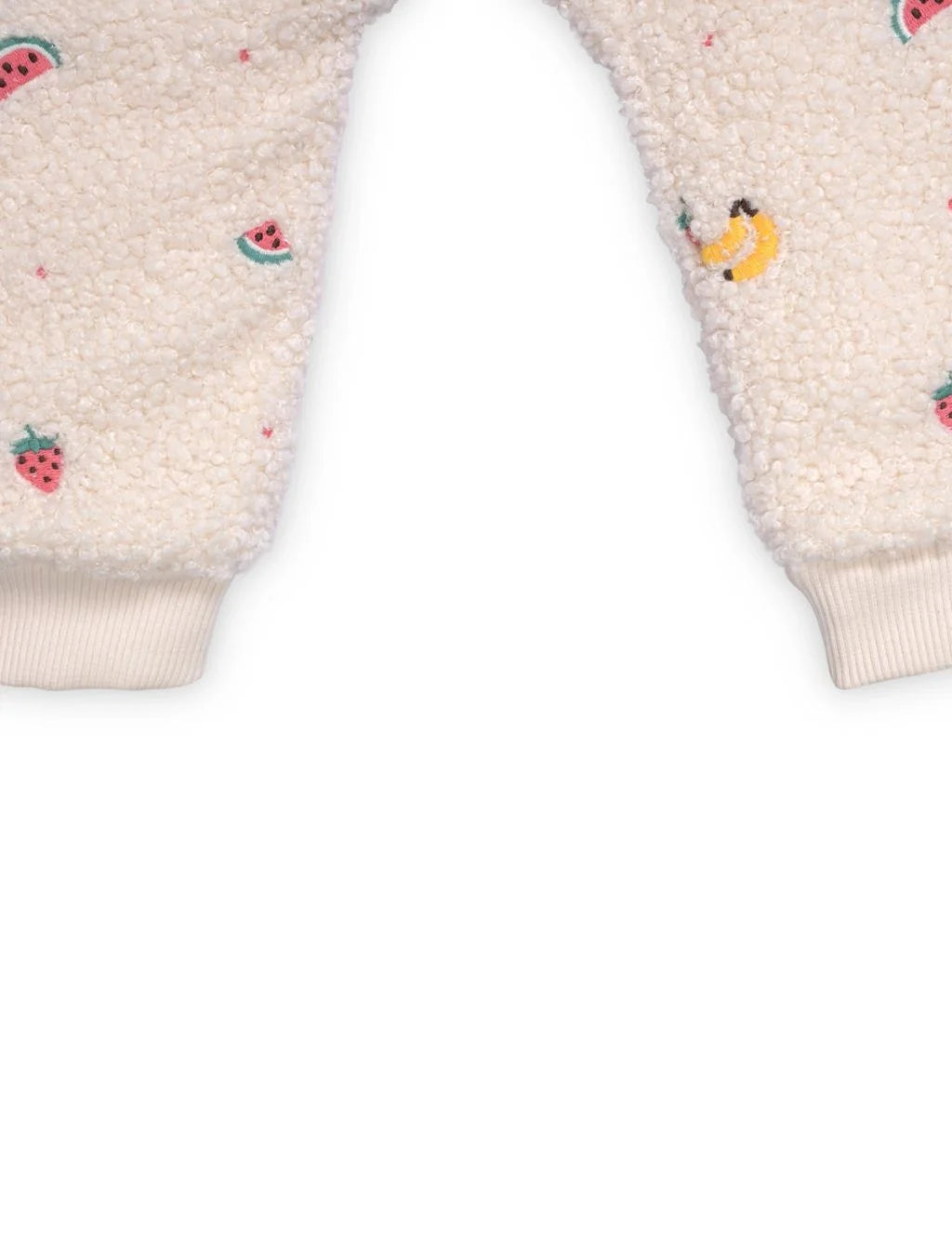 Close-up of a cream-colored garment with embroidered designs on a white background